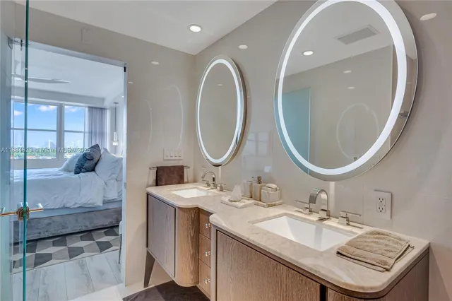 a bathroom with a granite countertop double vanity and a mirror