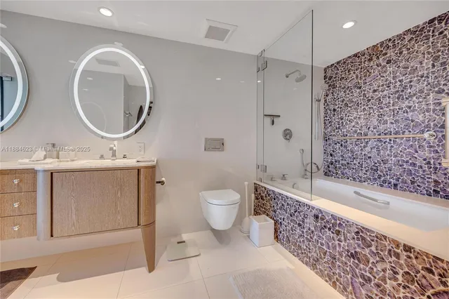a bathroom with a toilet a sink a mirror a bathtub and shower