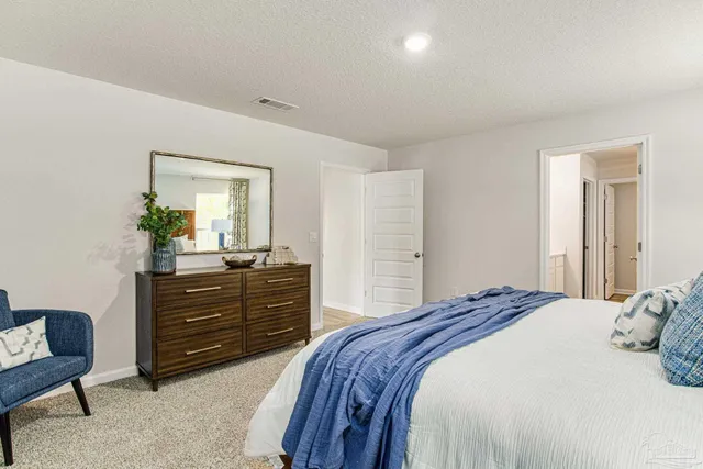 a bedroom with a bed and a mirror on dresser