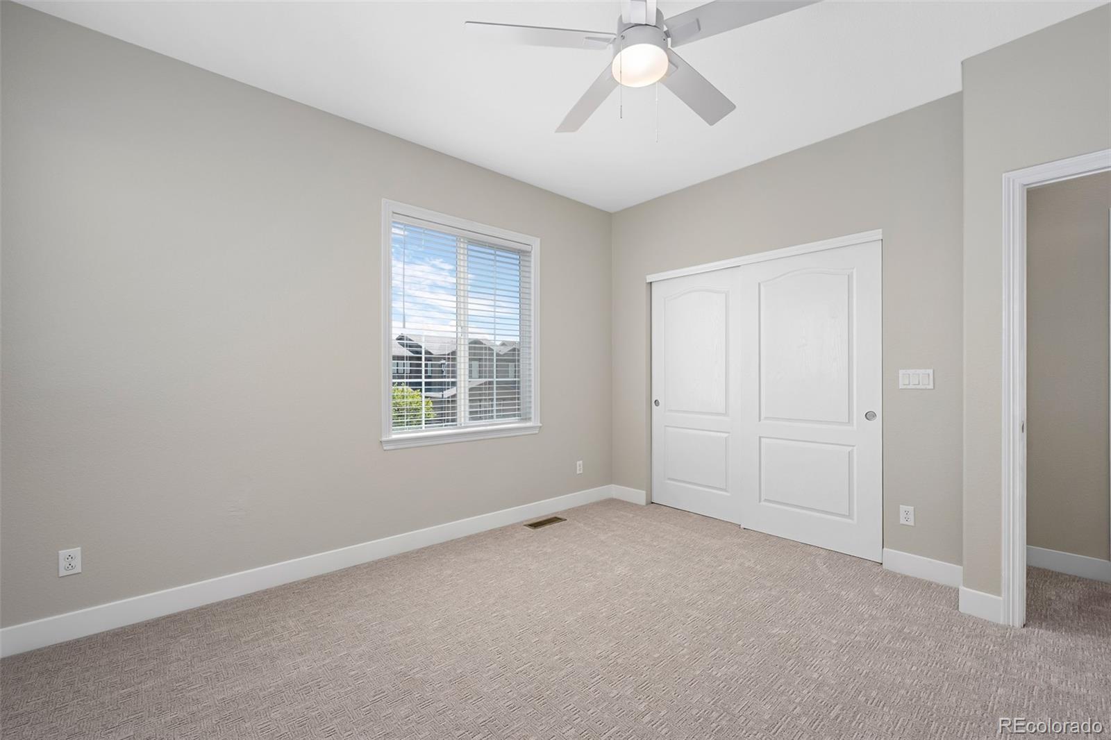 11036 Glengate Circle Highlands Ranch, CO 80130 - Photo 25 of 42 an empty room with a chandelier fan and windows