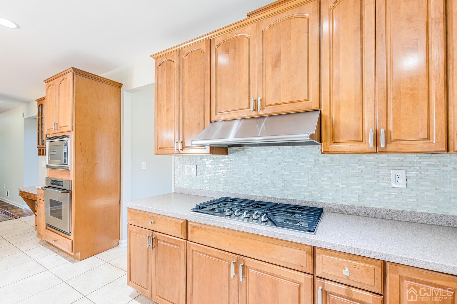 35 Utica Road Edison, NJ 08820 - Photo 22 of 76 a kitchen with stainless steel appliances a stove a microwave and cabinets