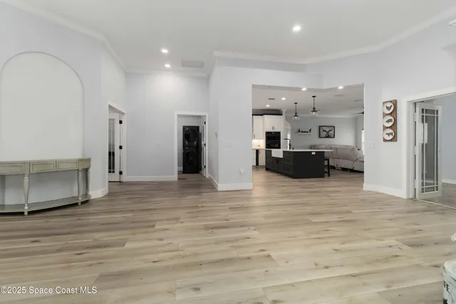 a open kitchen with stainless steel appliances granite countertop a stove a sink dishwasher a dining table and chairs with wooden floor