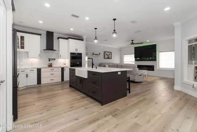 a kitchen with kitchen island granite countertop a sink appliances and cabinets