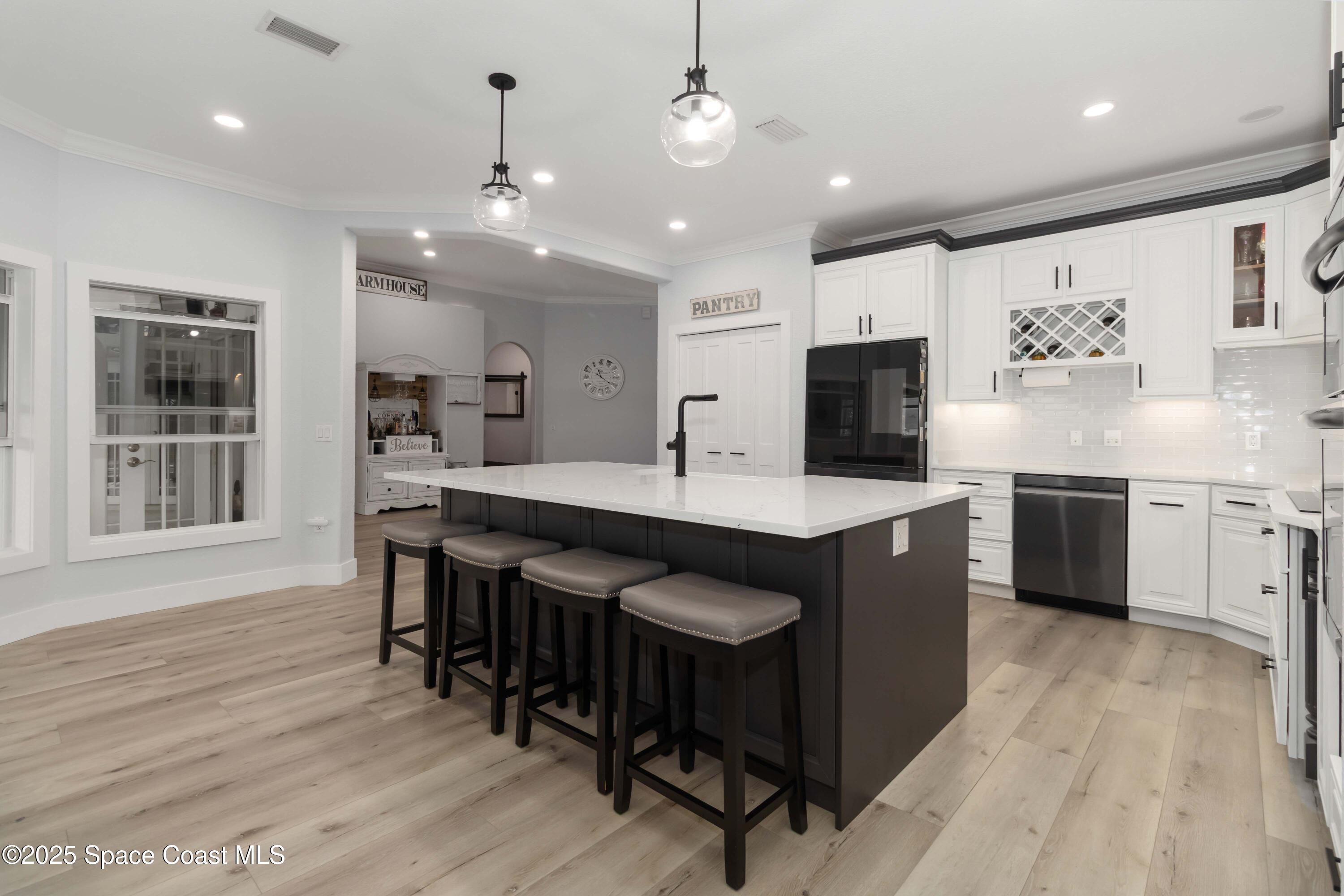 341 Buckskin Street Palm Bay, FL 32909 - Photo 20 of 69 a open kitchen with stainless steel appliances granite countertop a stove a sink dishwasher a dining table and chairs with wooden floor