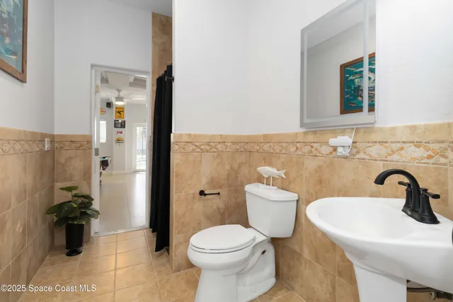 a bathroom with a granite countertop sink a toilet and a mirror