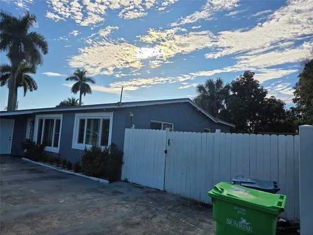 a backyard of a house with plants and wooden fence