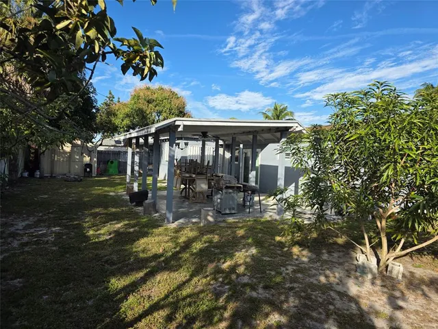 a view of a house with backyard and sitting area