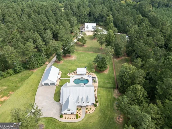 an aerial view of a house with a yard and lake view