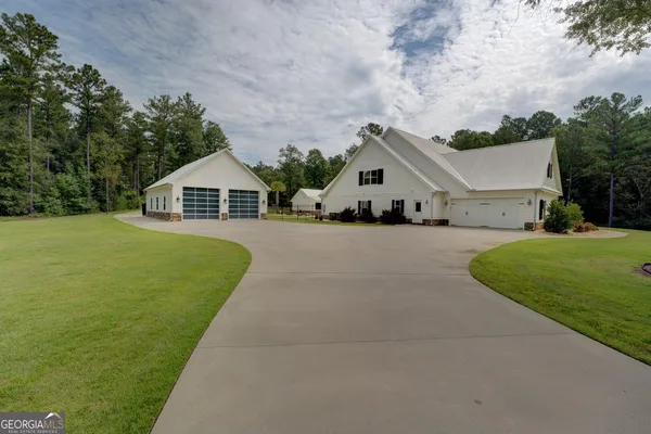 a kitchen with stainless steel appliances a stove a sink a refrigerator white cabinets and wooden floor