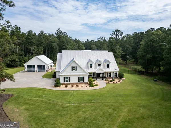 an aerial view of a house with swimming pool garden and bench