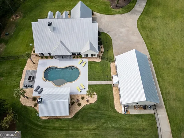 an aerial view of a house with a garden and a swimming pool