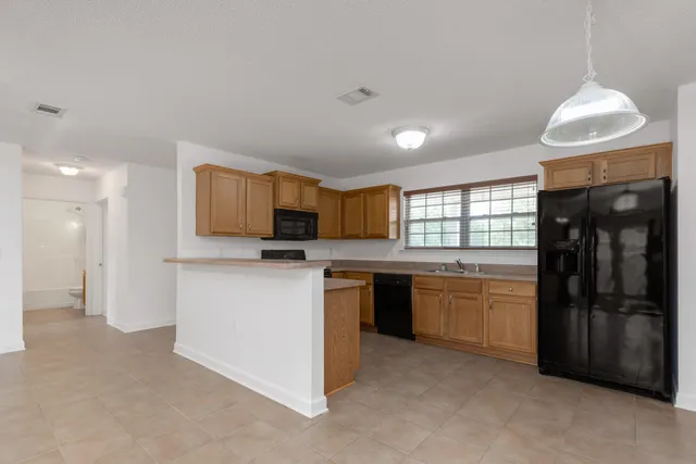 a kitchen with stainless steel appliances granite countertop a refrigerator and a stove top oven
