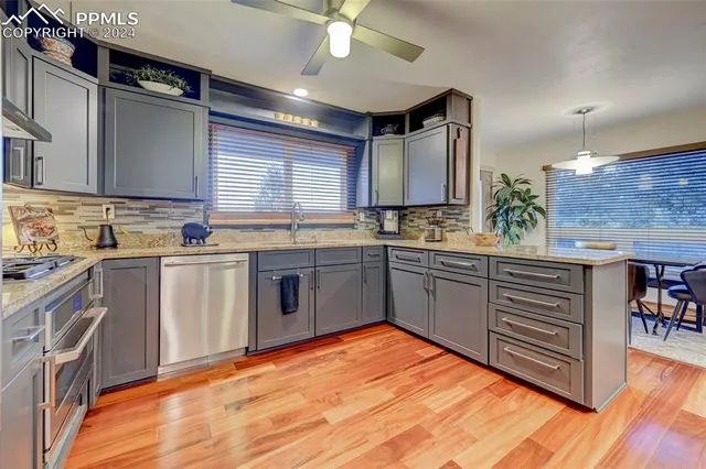 a kitchen with stainless steel appliances a sink cabinets and wooden floor