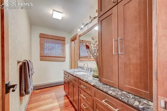 a bathroom with a granite countertop sink a mirror and shower