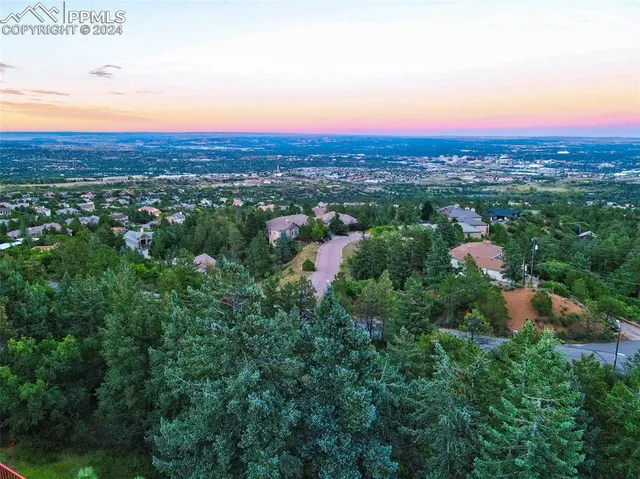 an aerial view of residential houses with outdoor space and trees