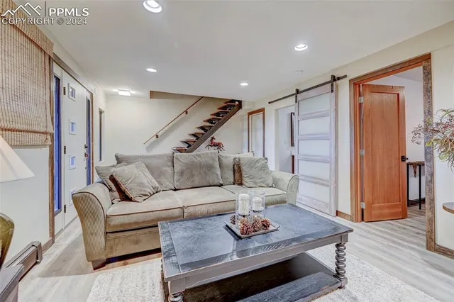 a living room with furniture and a wooden floor