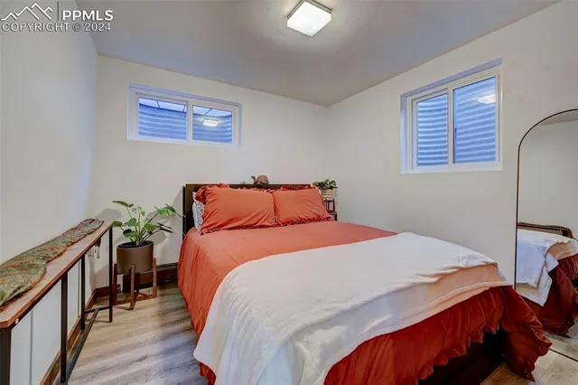 a bedroom with bed and wooden floor