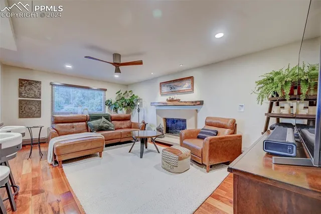 a living room with furniture fireplace and a large window