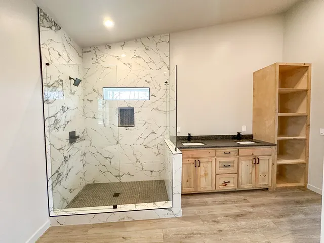 a bathroom with a granite countertop sink a mirror and shower
