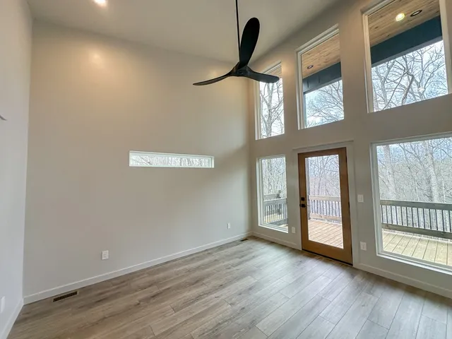 an empty room with wooden floor and windows