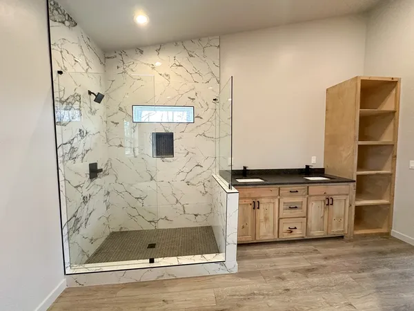 a bathroom with a granite countertop sink a mirror and shower