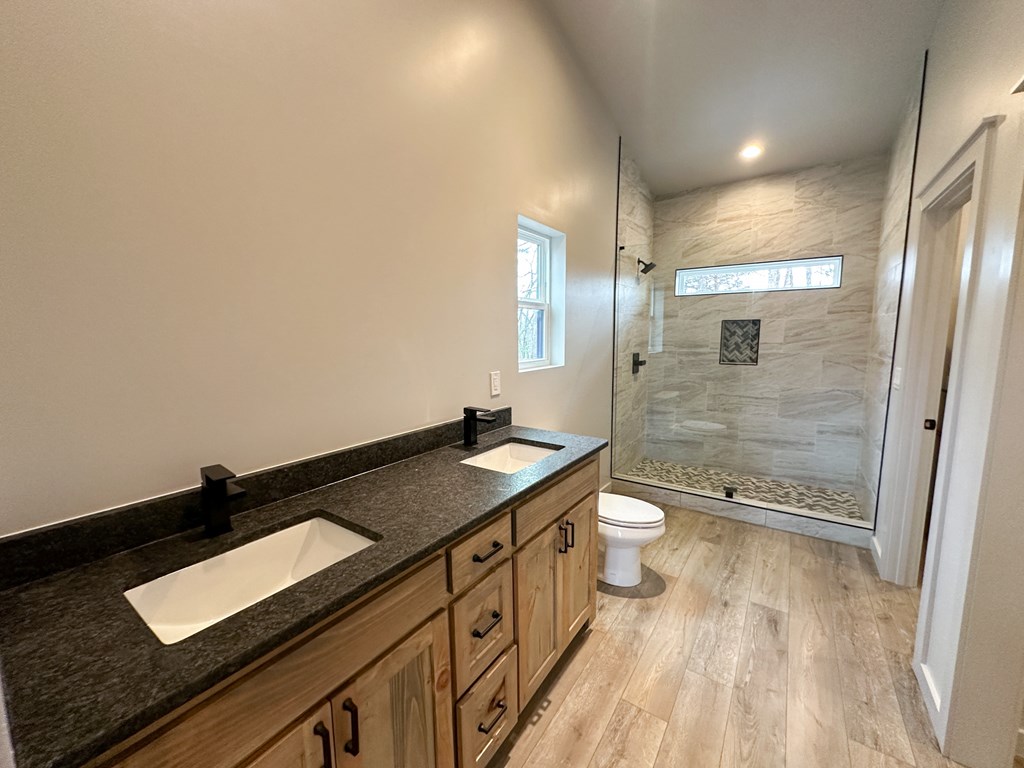 660 Old Toccoa Road Morganton, GA 30560 - Photo 26 of 45 a bathroom with a granite countertop sink a toilet a mirror and shower