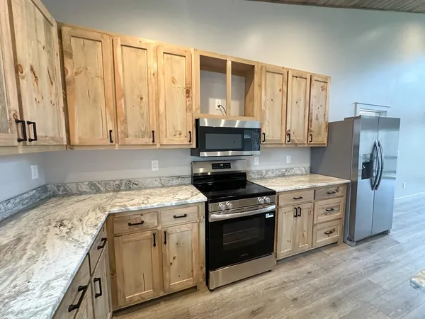 a kitchen with stainless steel appliances granite countertop a stove a sink and a refrigerator