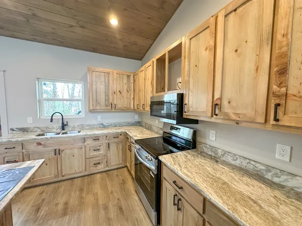 a kitchen with a stove sink and cabinets