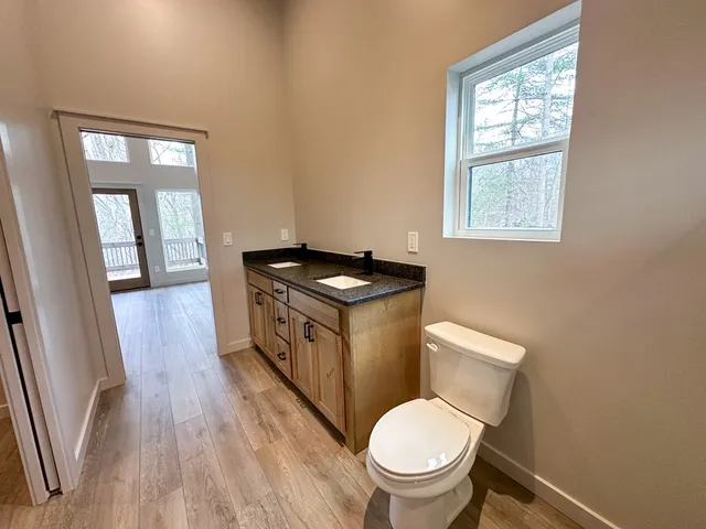 a bathroom with a toilet a sink and a window