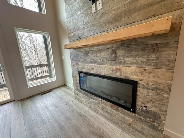 a living room with a fireplace wooden floor and a window