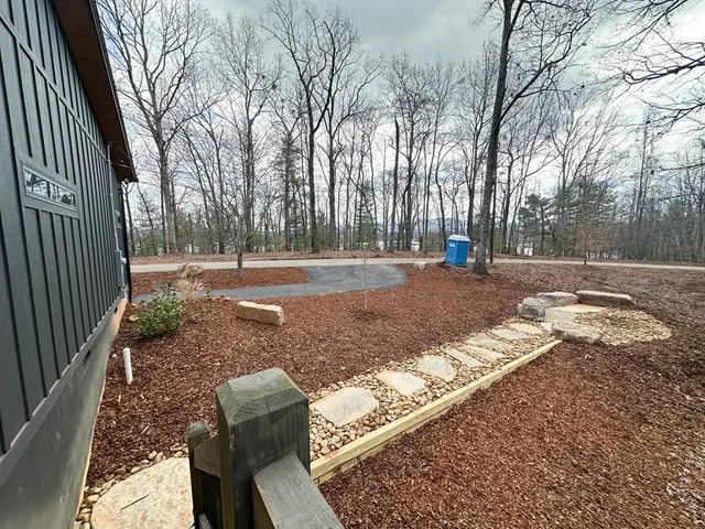 a view of a yard with trees in the background