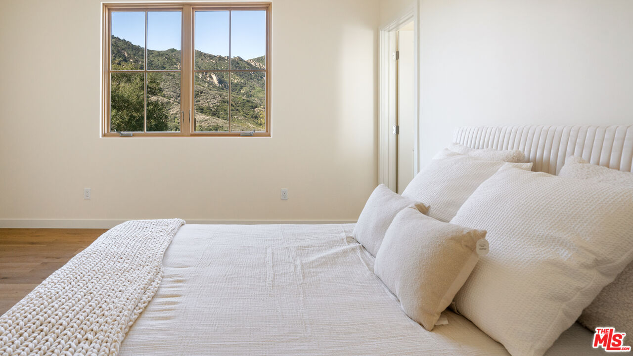 26255 Piuma Road Calabasas, CA 91302 - Photo 20 of 24 a bedroom with a large bed and a large window