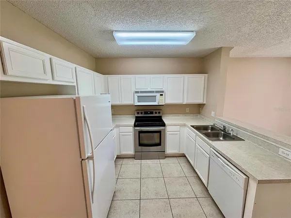 a kitchen with a stove a refrigerator and a sink