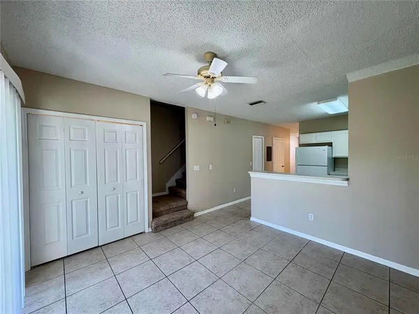 a view of a livingroom with a ceiling fan & a window