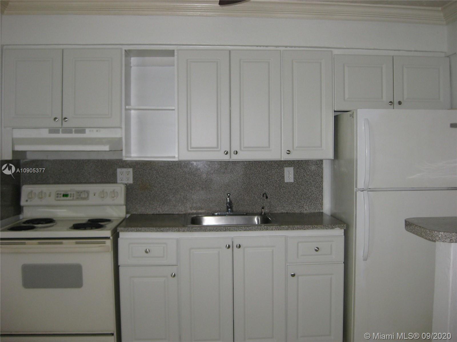 11 Southwest 32nd Avenue, Unit 1 Miami, FL 33135 - Photo 7 of 14 a kitchen with granite countertop white cabinets and white appliances