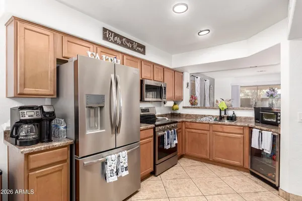 a kitchen with stainless steel appliances granite countertop a refrigerator a stove a sink and a refrigerator