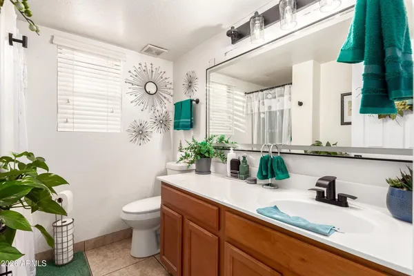 a bathroom with a granite countertop sink a toilet and a mirror