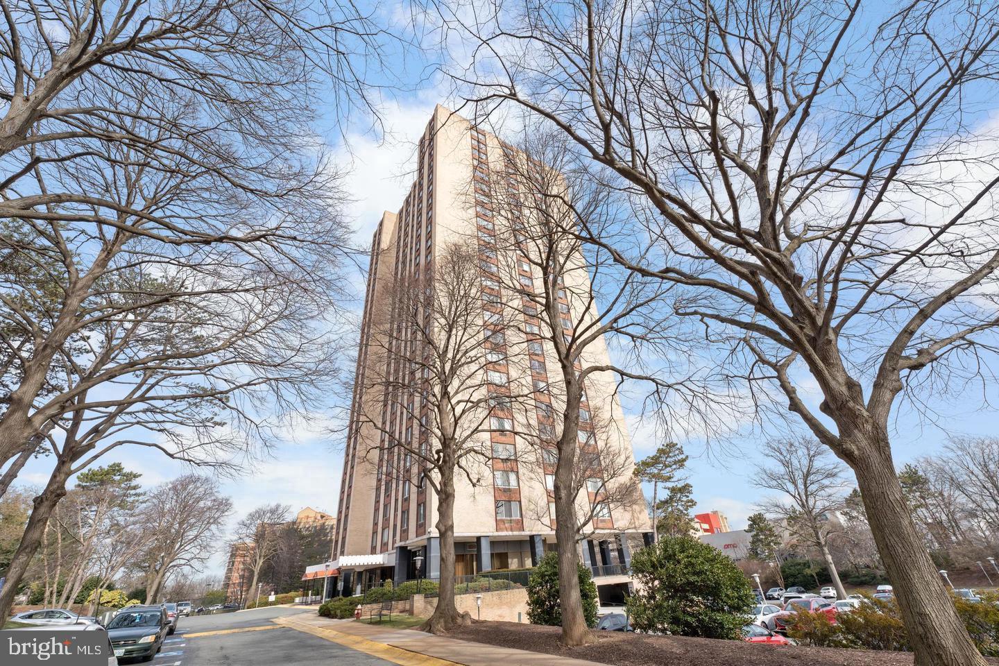 9701 Fields Road, Unit 301 Gaithersburg, MD 20878 - Photo 2 of 6 Modern high-rise amidst serene trees.