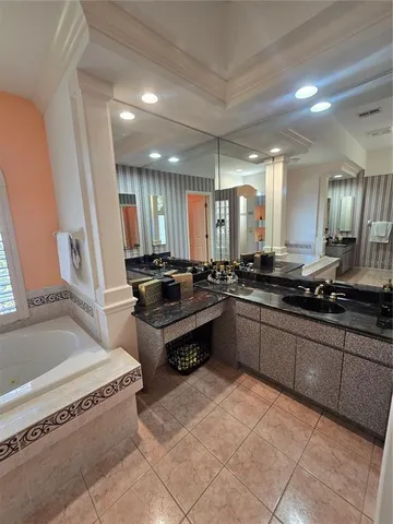 a bathroom with a tub a sink and a mirror
