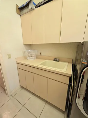 a kitchen with a sink a stove cabinets and utility