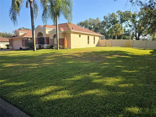 a front view of house with yard and trees in the background