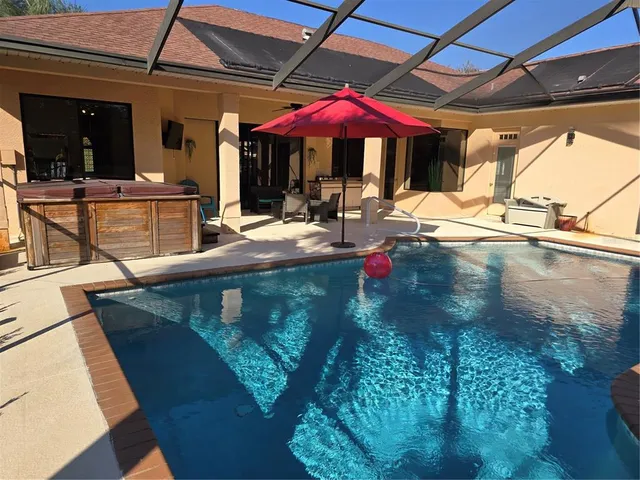 a view of a patio with a table and chairs under an umbrella