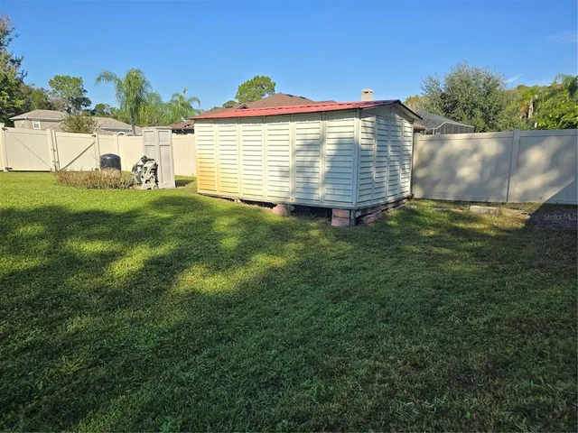 a view of a house with a yard and basketball ground