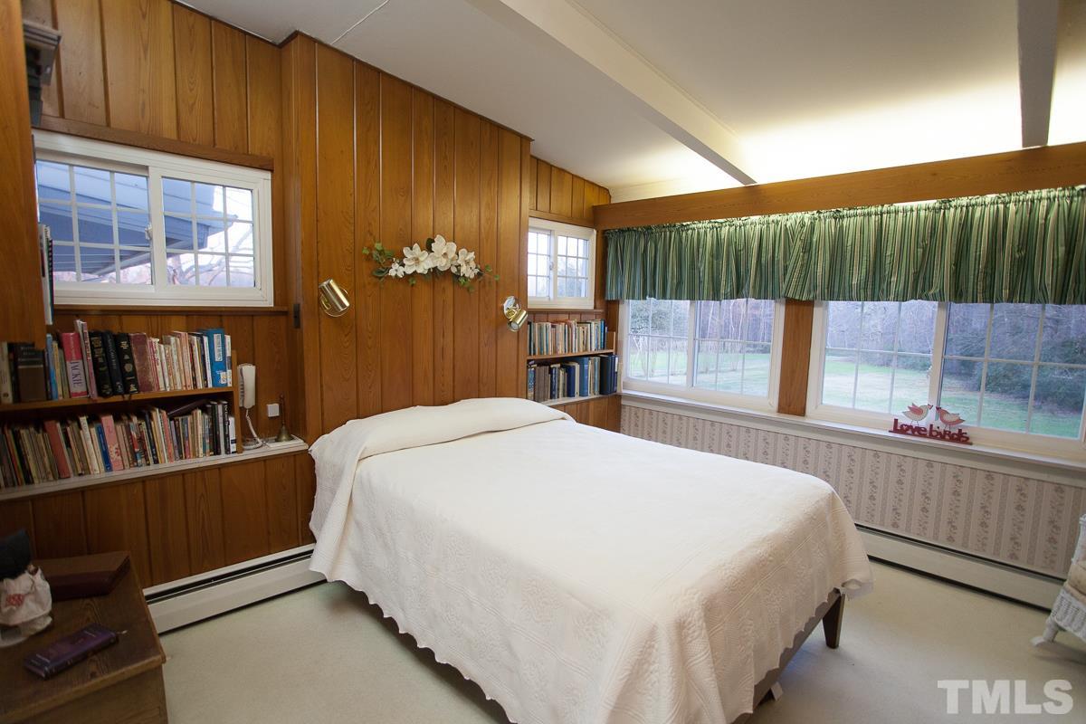 245 Weldon Wrenn Road Roxboro, NC 27574 - Photo 13 of 25 a bed sitting in a bedroom next to a book shelf