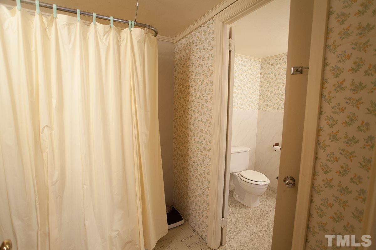 245 Weldon Wrenn Road Roxboro, NC 27574 - Photo 5 of 25 a bathroom with a shower curtain and a sink