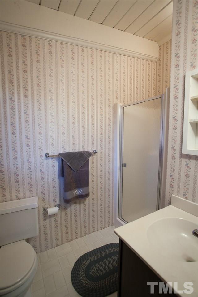 245 Weldon Wrenn Road Roxboro, NC 27574 - Photo 8 of 25 a bathroom with a toilet a sink and bathtub