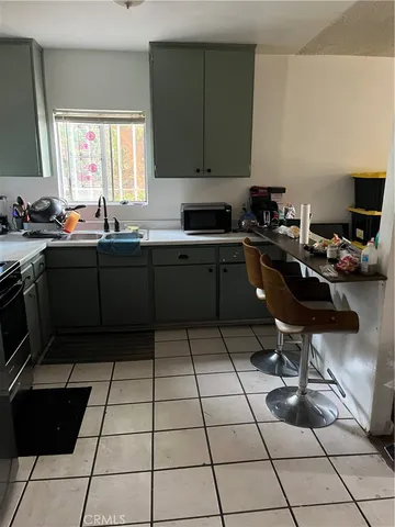 a kitchen with a sink a stove and a wooden cabinets