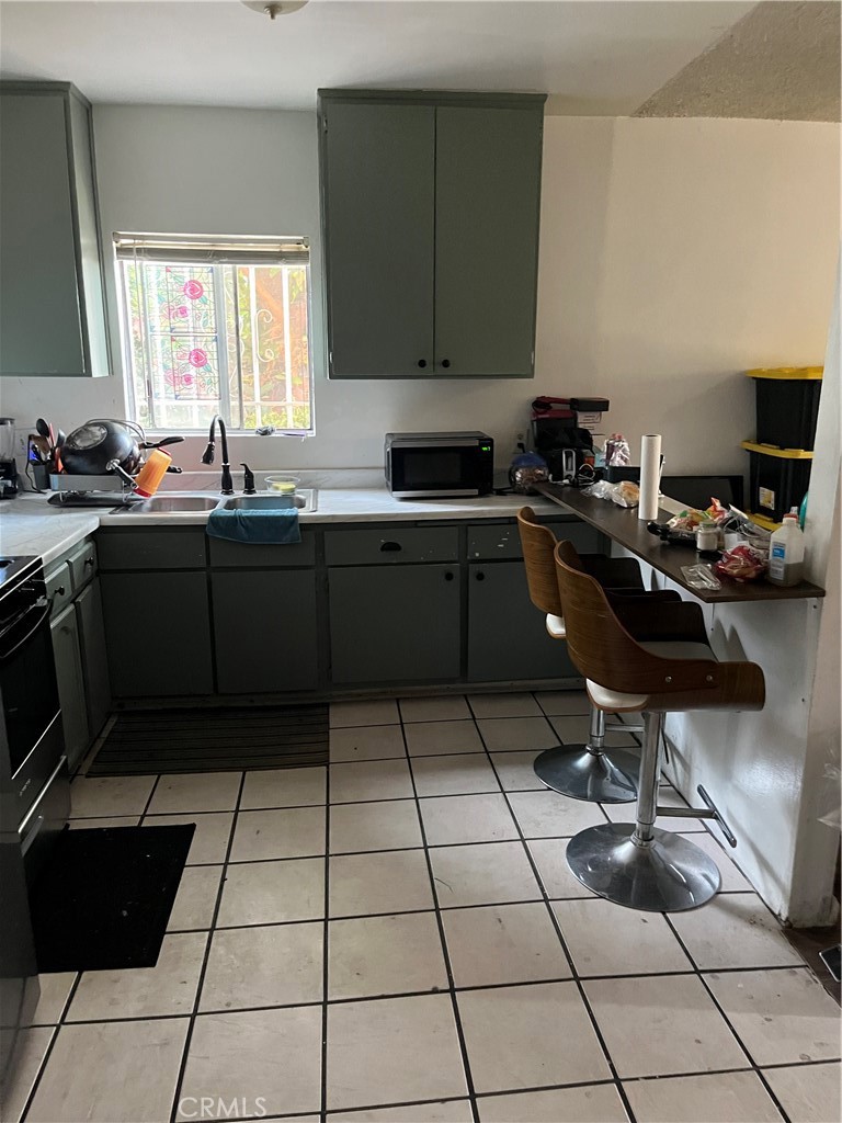 201 West Raymond Street Compton, CA 90220 - Photo 14 of 19 a kitchen with a sink a stove and a wooden cabinets