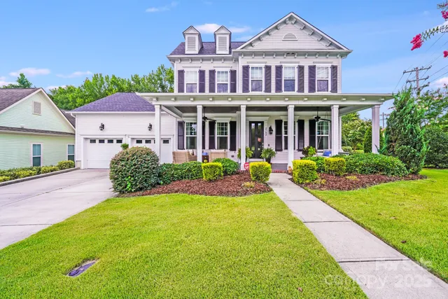 a front view of a house with a yard and potted plants