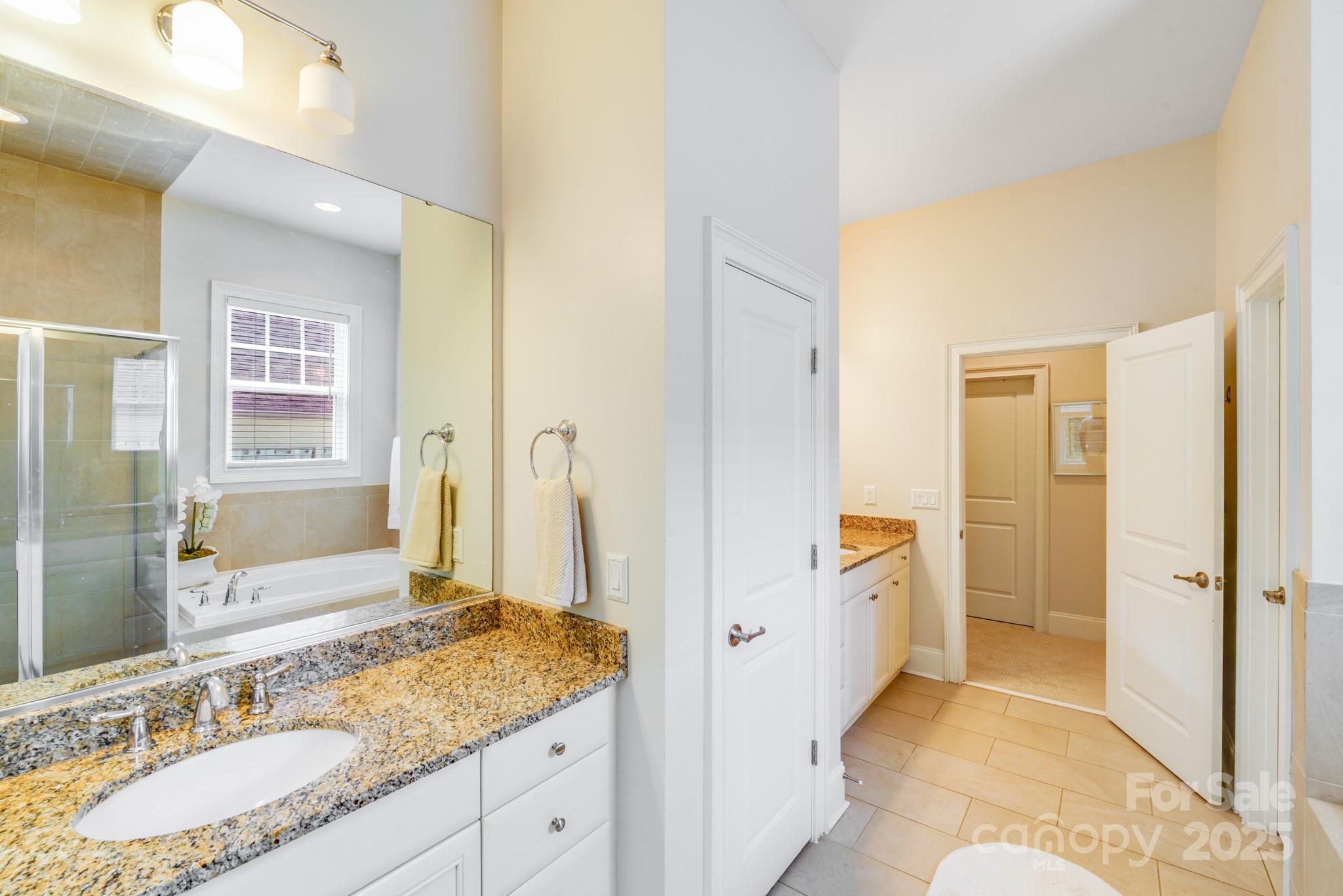 2702 Arsdale Road Waxhaw, NC 28173 - Photo 31 of 48 a spacious bathroom with a granite countertop sink mirror and a shower